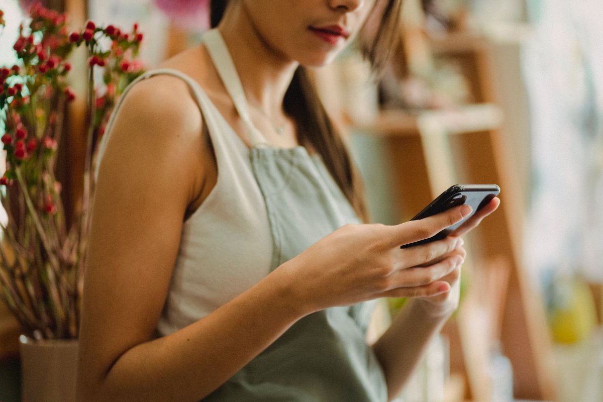 Una negoziante risponde dal telefono ai messaggi dei clienti